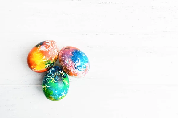 Trois œufs de Pâques colorés en groupe sur fond blanc en bois avec espace de copie. Nourriture traditionnelle de vacances pour Pâques — Photo