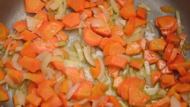 将切碎的蔬菜 胡萝卜和洋葱 与油一起放进金属锅的过程 闭包视图 — 图库视频影像