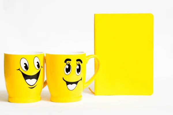 Zwei lustige Tassen mit paarweisem Lächeln und Notizbuch für Menü oder Rezept oder Planung — Stockfoto