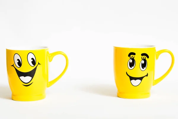 Relationshio concept with two happy yellow cups on white background