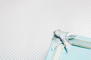 Blue gift box with silver bow over silver textured background
