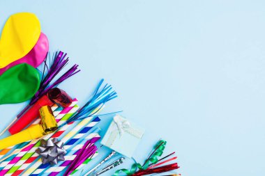 Various colorful birthday accessories on blue background. Copy space. Flat lay
