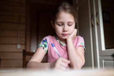 Masada ödev yapan bir kız.