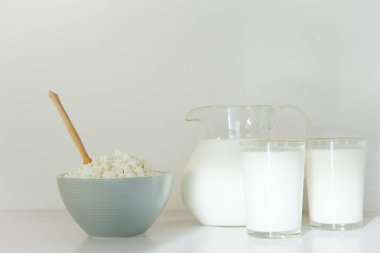 Cam kavanozda süt ve masada süzme peynir. Sağlıklı gıda kavramı.