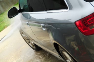 Yüksek basınçlı su kullanarak arabayı temizlemek. Açık hava. 