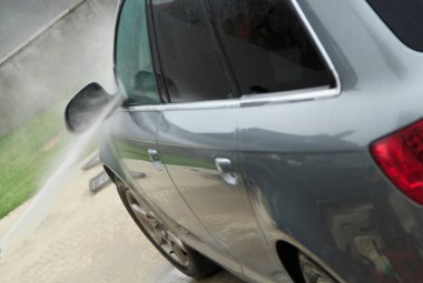 Yüksek basınçlı su kullanarak arabayı temizlemek. Açık hava. 