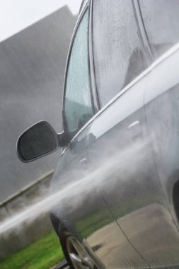 Yüksek basınçlı su kullanarak arabayı temizlemek. Açık hava. 