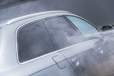 Yüksek basınçlı su kullanarak arabayı temizlemek. Açık hava. 