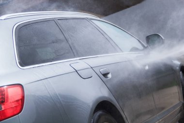 Yüksek basınçlı su kullanarak arabayı temizlemek. Açık hava. 