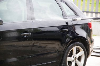 Yüksek basınçlı su kullanarak arabayı temizlemek. Açık hava. 