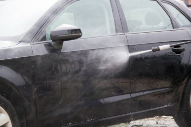 Yüksek basınçlı su kullanarak arabayı temizlemek. Açık hava. 