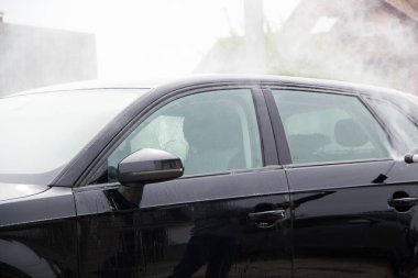 Yüksek basınçlı su kullanarak arabayı temizlemek. Açık hava. 