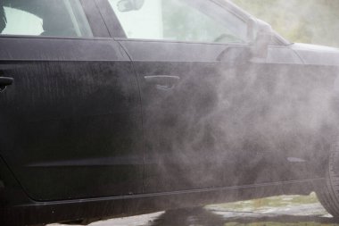 Yüksek basınçlı su kullanarak arabayı temizlemek. Açık hava. 