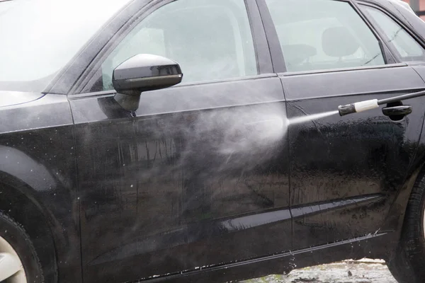 Yüksek basınçlı su kullanarak arabayı temizlemek. Açık hava. 