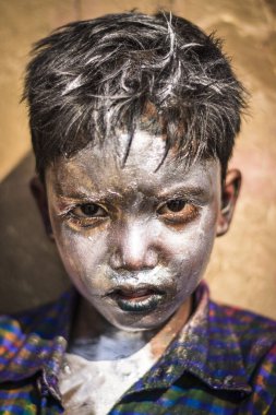 Varanasi, Hindistan - 13 Mart 2017: Yüzü gümüş boyayla kaplı Hintli bir çocuğun portresi Holi festivalini kutluyor, Hindistan 'da renkler festivali.