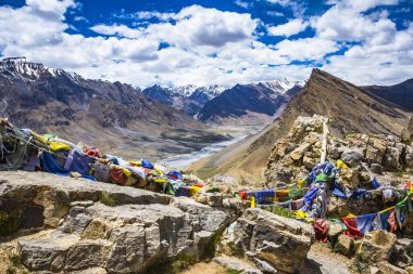 Spiti Vadisi 'nin (Hindistan' ın kuzeyi) manzarası Himalaya dağlarını ve Budistler tarafından çevreyi kutsamak için kullanılan renkli dua bayraklarını gösteriyor..