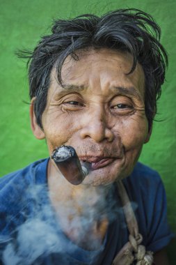Kyaiktiyo Dağı, Myanmar- 6 Şubat 2017: Birmanyalı bir adamın pipo içişi portresi.