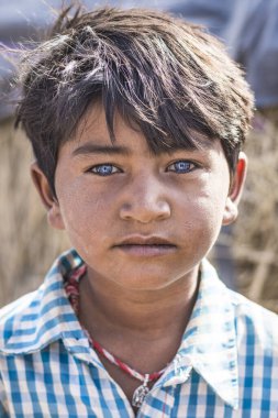 Jaisalmer, India- 11 Nisan 2017: Thar Çölü 'ndeki köyünde Jaisalmer, Hindistan yakınlarındaki güzel mavi gözlü bir çingene çocuğun portresi.