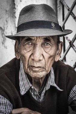 Macleod Ganj, Hindistan - 28 Nisan 1017: Şapka kullanan ve fotoğrafçılığa poz veren zarif yaşlı bir adamın portresi.