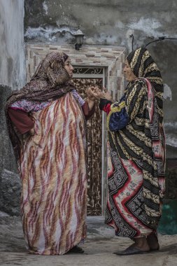 Taghazout, Fas - 16 Ocak 2015: İki geleneksel Faslı kadın, Fas 'ın Taghazout kentinde küçük bir balıkçı köyünde konuşuyorlar..