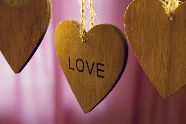 Saint Valentin coeurs en bois avec mot amour sur fond rose — Photo