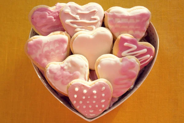 Weiße und rosa Kekse mit Zuckerguss in Herzform in Bo — Stockfoto