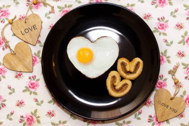 Bisküvi ve yumurta bir kalp şeklinde ve ahşap kalpler bileşimi. Sevgililer günü
