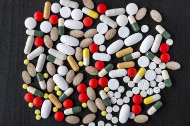 Avuç siyah arka plan üzerine çeşitli renk hap