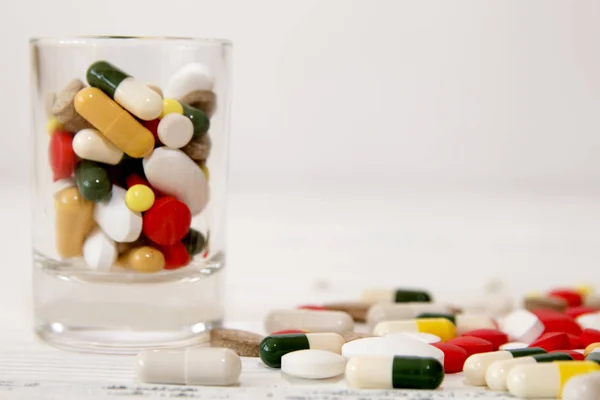 Avuç içinde cam beyaz masa üzerinde çeşitli renk hap