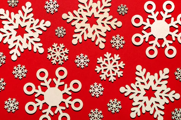 Muster von hölzernen Schneeflocken auf rotem Hintergrund — Stockfoto