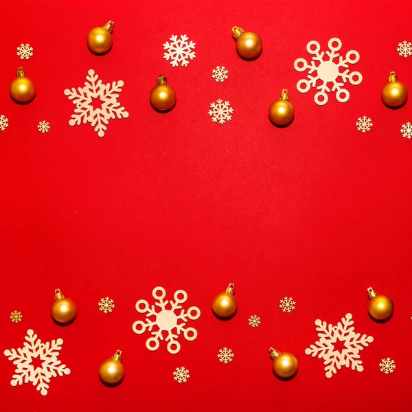 Mönster av trä snöflingor och guld nyår bollar på en röd ba — Stockfoto