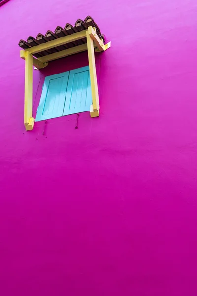 Parlak, pembe duvarındaki küçük bir pencere içinde kapalı panjurlar