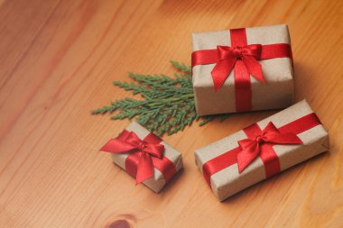 Bazı hediye kutuları kahverengi zanaat kağıt sarılmış ve kravat kırmızı saden kurdele. Dekoratif ahşap arka plan. Metin alanınız. Hediyeler seti.