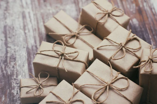 一些礼品盒用褐色工艺纸包着 系着麻绳 装饰木制背景 你的文字空间 一套礼物 圣诞礼物 假日气氛 新年装潢 礼品交换 — 图库照片