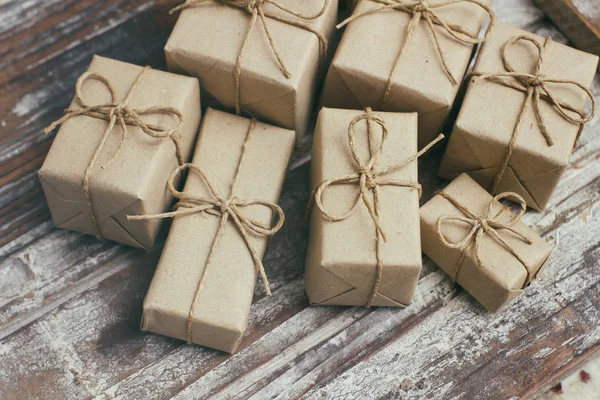 一些礼品盒用褐色工艺纸包着 系着麻绳 装饰木制背景 你的文字空间 一套礼物 圣诞礼物 假日气氛 新年装潢 礼品交换 — 图库照片