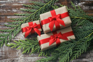 Bazı hediye kutuları kahverengi zanaat kağıt sarılmış ve kravat kırmızı saden kurdele. Dekoratif ahşap arka plan. Metin alanınız. Hediyeler seti.