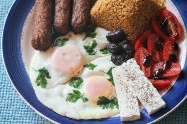 Geleneksel Akdeniz yemeği. Bulgur, sosis, feta peyniri, balzamik soslu domates, otlu omlet, siyah zeytin..