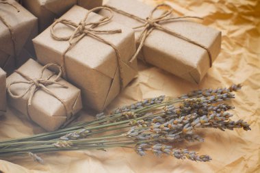 Kahverengi hediye kutuları seti. Zanaat kağıt sarılmış ve kenevir kablosu ile bağlı. Eski kağıt arka plan. Küçük lavanta buketi.