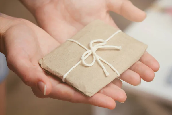 Tenez Boîte Cadeau Présenté Enveloppé Dans Papier Artisanal Ruban Satin Images De Stock Libres De Droits