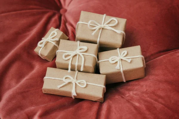圣诞节的礼物 礼品盒用手工纸包好 系上白线 红色天鹅绒布背景 假日气氛 — 图库照片