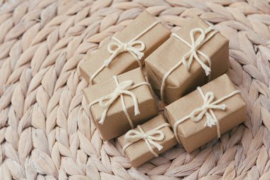 Kahverengi el işi kağıdına sarılı paketler ve kenevir teli. Paket var. Teslimat servisi. İnternetten alışveriş. Satın alın. Hediye kutusu masanın üstünde. Dekoratif ahşap arka plan.