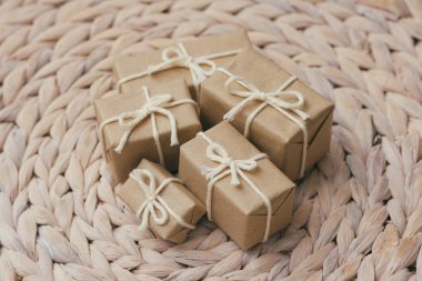 Kahverengi el işi kağıdına sarılı paketler ve kenevir teli. Paket var. Teslimat servisi. İnternetten alışveriş. Satın alın. Hediye kutusu masanın üstünde. Dekoratif ahşap arka plan.