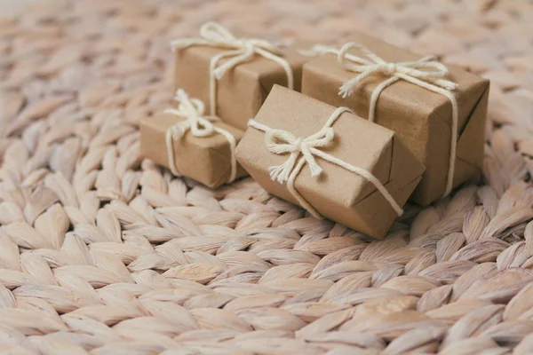 Set of parcels wrapping in brown craft paper and tie hemp string. Package. Delivery service. Online shopping. Your purchase. Gift box on a table. Decorative wood background.