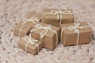 Kahverengi el işi kağıdına sarılı paketler ve kenevir teli. Paket var. Teslimat servisi. İnternetten alışveriş. Satın alın. Hediye kutusu masanın üstünde. Dekoratif ahşap arka plan.