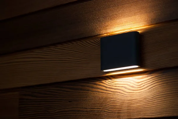 A luminária na parede é revestida com madeira. Luz de parede — Fotografia de Stock