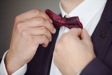 Adamın elleri bir papyon giyiyor