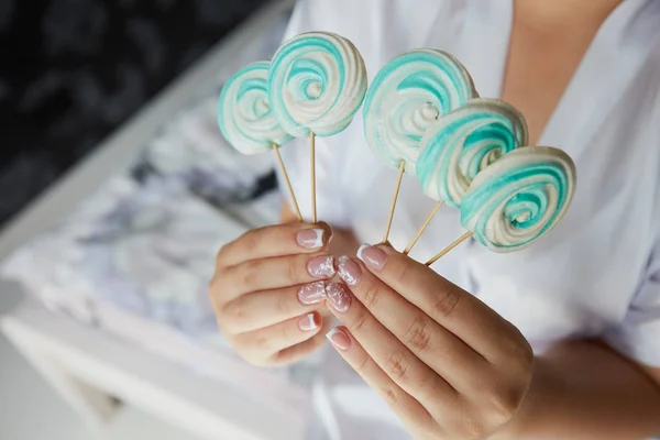 Зеленые и белые сладости на палочке в руках невесты — стоковое фото