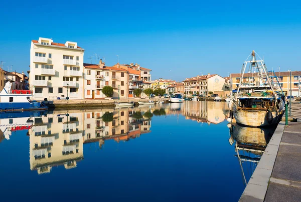 Grado, Italia: Casas y barcos de colores con sus reflejos en el agua de uno de los canales de Grado —  Fotos de Stock