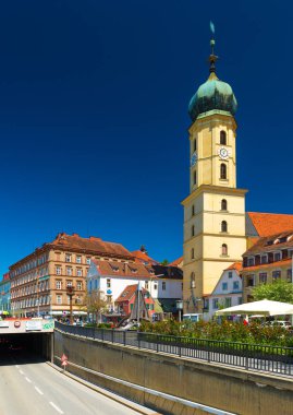 Graz, Avusturya: Sarı Fransisken Kilisesi ve eski tarihi binaların mavi gökyüzü turuncu çatı. Yol trafik ile şehir merkezine