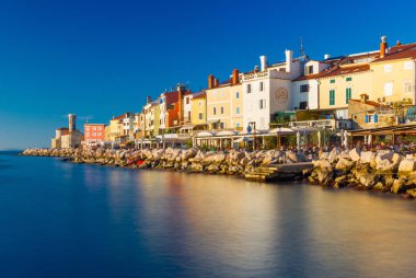 Piran, Slovenya: Eski şehir merkezinin görünümü Adriyatik Denizi, kasaba Piran karşı açık mavi gökyüzü günbatımı, kıyı şeridi boyunca su yansıması